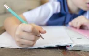 Student holding pencils for math calculation, homework.