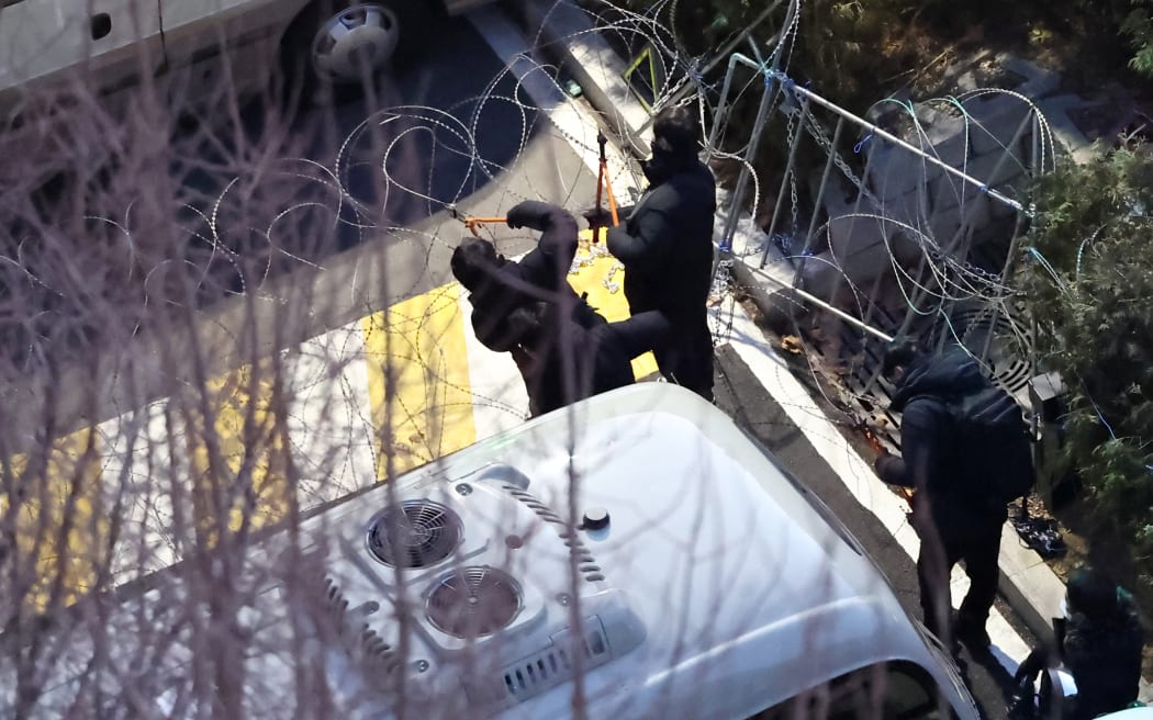 Police officers remove barbed wire fences around the presidential residence as they attempt to enter after a motorcade believed to be carrying South Korean impeached president Yoon Suk Yeol left earlier in Seoul on January 15, 2025. After authorities entered his residence to arrest him, South Korea's impeached President Yoon Suk Yeol agreed on January 15 to appear at the office of investigators probing him over insurrection, his lawyer said. (Photo by YONHAP / AFP) / - South Korea OUT / NO USE AFTER JANUARY 25, 2025 02:20:08 GMT -  - SOUTH KOREA OUT / NO USE AFTER JANUARY 25, 2025 02:20:08 GMT -  - SOUTH KOREA OUT / NO ARCHIVES -  RESTRICTED TO SUBSCRIPTION USE