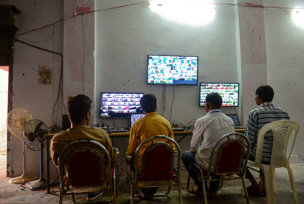 Counting agents from different political parties observe CCTV footage inside a vote counting centre at Mundera Mandi where Electronic Voting Machines are being kept on the eve of the counting day in India's general election in Allahabad.