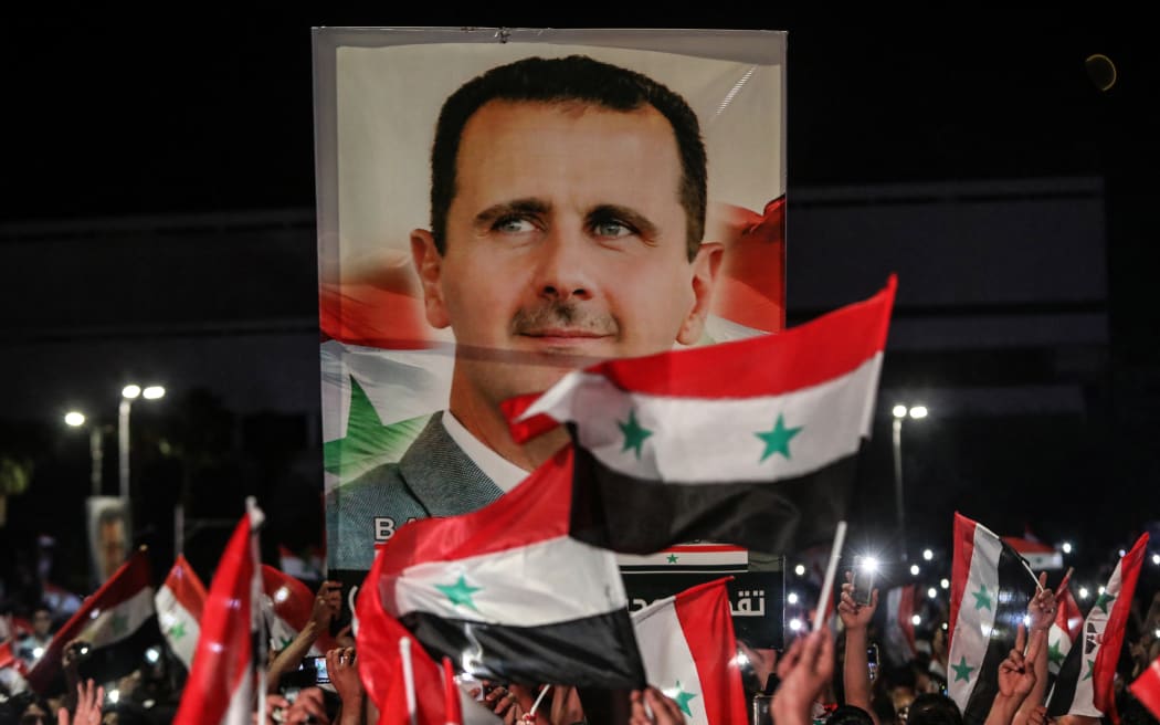 Syrians waved national flags and carried portraits of their president Bashar al-Assad in the capital Damascus yesterday, a day after the election.