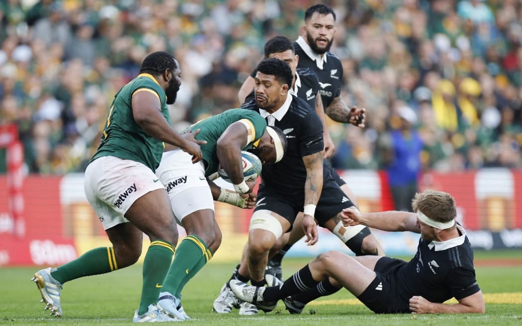 New Zealand's number eight Ardie Savea (C) tackles South Africa's flanker Siya Kolisi (2nd L) during the Rugby Championship Test match between South Africa and New Zealand at the Ellis Park Stadium in Johannesburg on August 31, 2024. (Photo by PHILL MAGAKOE / AFP)