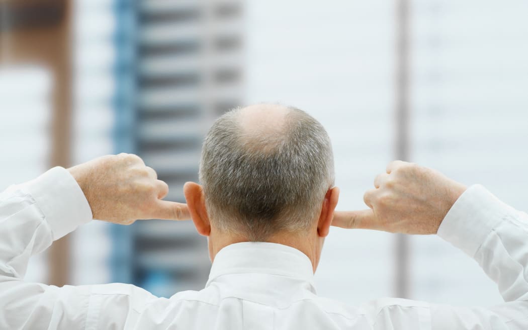 Man putting his fingers in his ears (Photo by Huber & Starke / Image Source / Image Source via AFP)