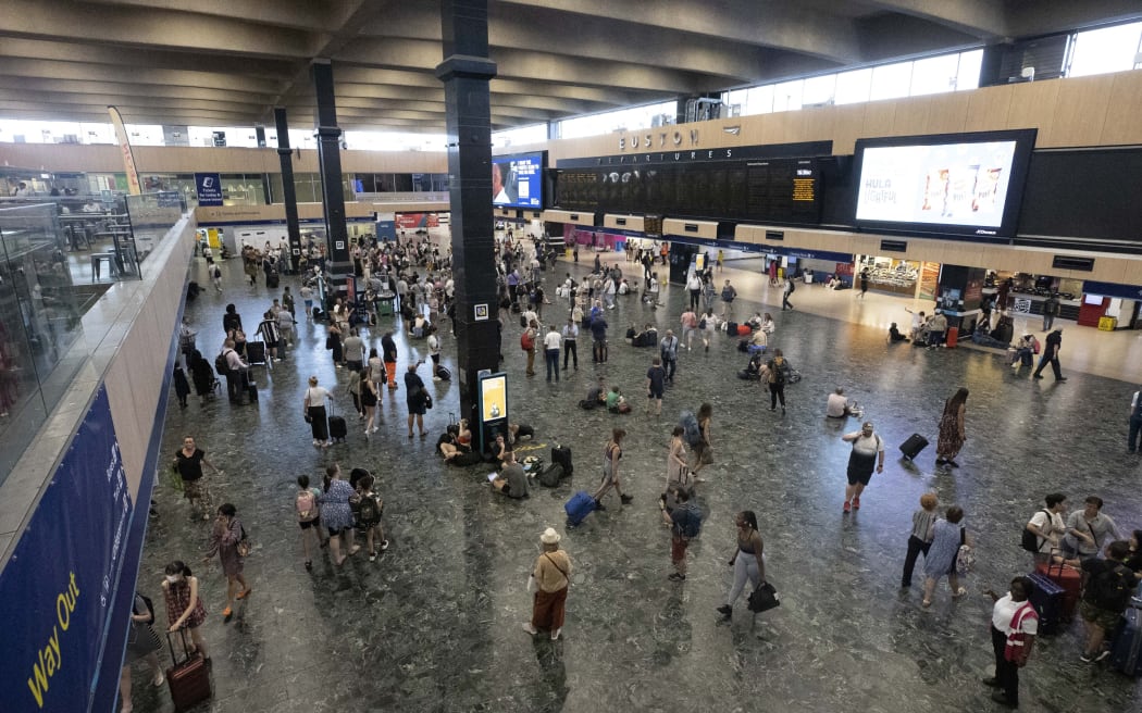 Passengers at a train station in London, as services in extreme temperatures.