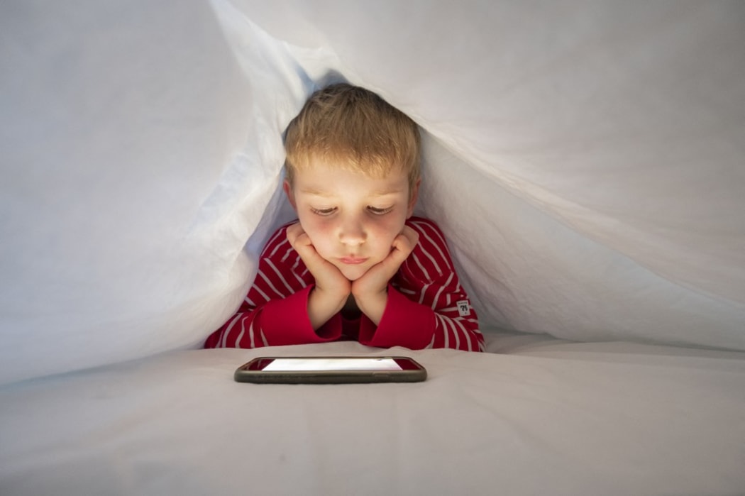 Boy in his bed using smartphone to make a video call. (Photo by CONCEPTUAL IMAGES/SCIENCE PHOTO / PHR / Science Photo Library via AFP)