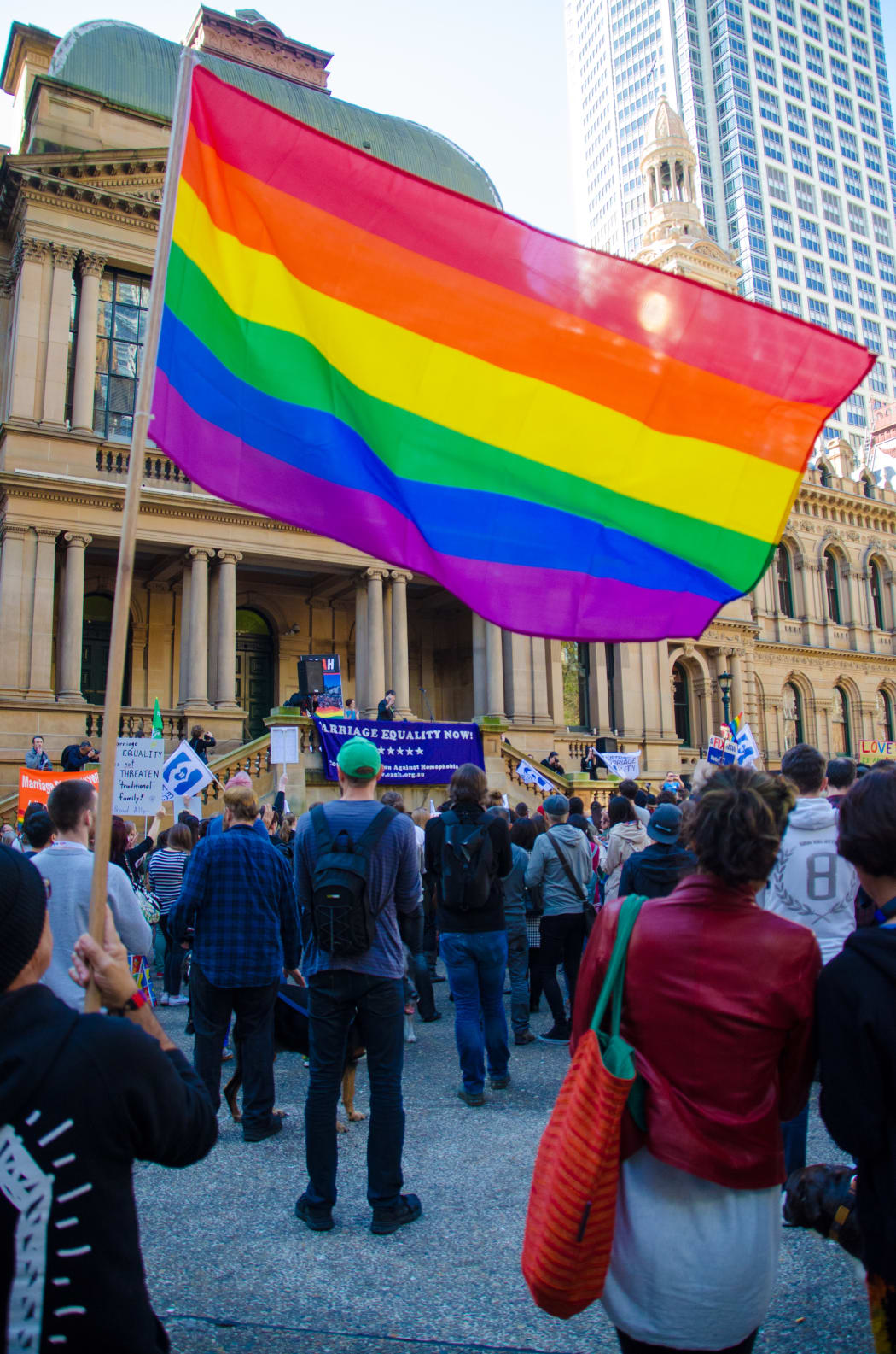 A protester waves a rainbow coloured flag at a marriage equality rally outside Town Hall in Sydney, Australia on August 9, 2015.