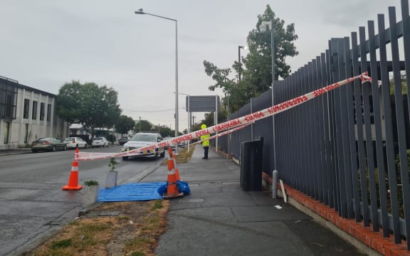 A police guard outside the Christchurch City Mission on Hereford Street following last night's fatal stabbing of a 22-year-old man.
