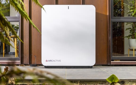 a white battery system against an outside wall