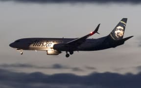 Alaska Airlines Boeing 737-800 aircraft as seen landing at dusk time at Ronald Reagan Washington National Airport DCA in Arlington County, Virginia over the Potomac River in the United States of America, flying over the water with reflections and the illuminated lights from the buildings. The arriving B737 passenger airplane is a Boeing 737-890 equipped with scimitar winglets. Alaska Airlines is a major American airline headquartered in SeaTac, Washington, within the Seattle metropolitan area. It is the fifth-largest airline in North America when measured by scheduled passengers carried. Alaska is member of the Oneworld aviation alliance group. Washington DC, USA on May 2023 (Photo by Nicolas Economou/NurPhoto) (Photo by Nicolas Economou / NurPhoto / NurPhoto via AFP)