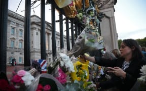 Wellwishers arrive to place flowers at the gates of Buckingham Palace, after the announcement of the death of Queen Elizabeth II, in central London on September 9, 2022.