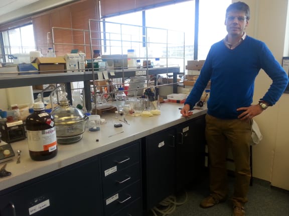A photo of Shane Telfer at his work bench in the lab