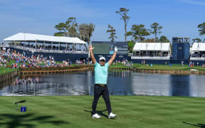 Ryan Fox of New Zealand celebrates after holing his tee shot on the 17th hole for a hole in one during the first round of The Players Championship at TPC Sawgrass, 2024