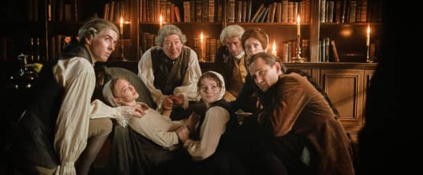 From L to R: Matthew Beard, Amanda Seyfried, Scott Handy, Thomasin McKenzie, Jeremy Wheeler, Stacy Martin, and Lewis Pullman in The Testament Of Ann Lee.