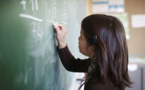 girl writing on blackboard