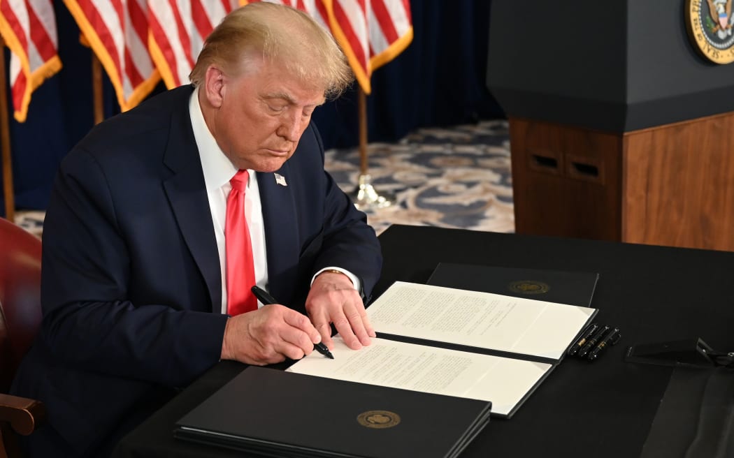 US President Donald Trump signs executive orders extending coronavirus economic relief, during a news conference in Bedminster, New Jersey, on August 8, 2020.