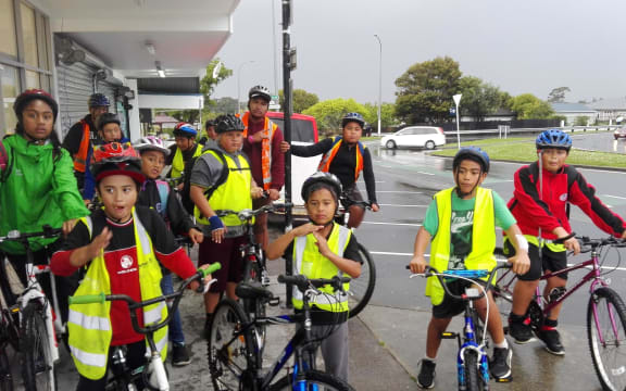 A group of kids in Hi-Viz vests with bikes