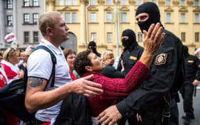 Protesters speak with Belarusian special police officers while opposition supporters rally to protest against disputed presidential elections results in Minsk on August 30, 2020