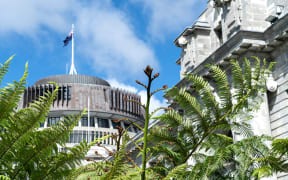 New Zealand Government buildings, House neo classical style House of Parliament with Beehive behind with iconic ponga fern frond one of NZ's emblems.