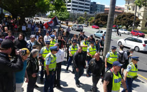 Police escort National Front members away from Parliament.