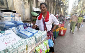 A street vendor sells face masks near Sule Pagota, a shopping district in Yangon, Myanmar on Jan. 27, 2022. Myanmar will mark the first anniversary of the military coup on February 1st.