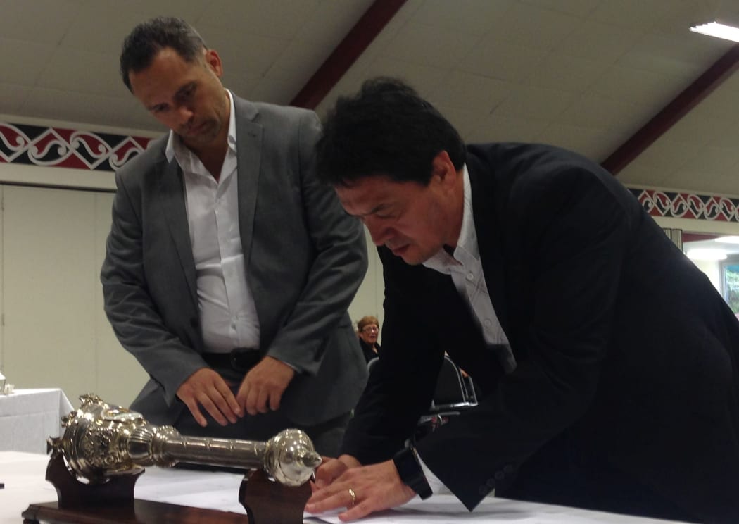 Port Nicholson Block Settlement Trust chief executive Jason Fox waits while chairman Wayne Mulligan signs MoU for Taranaki Whanui.