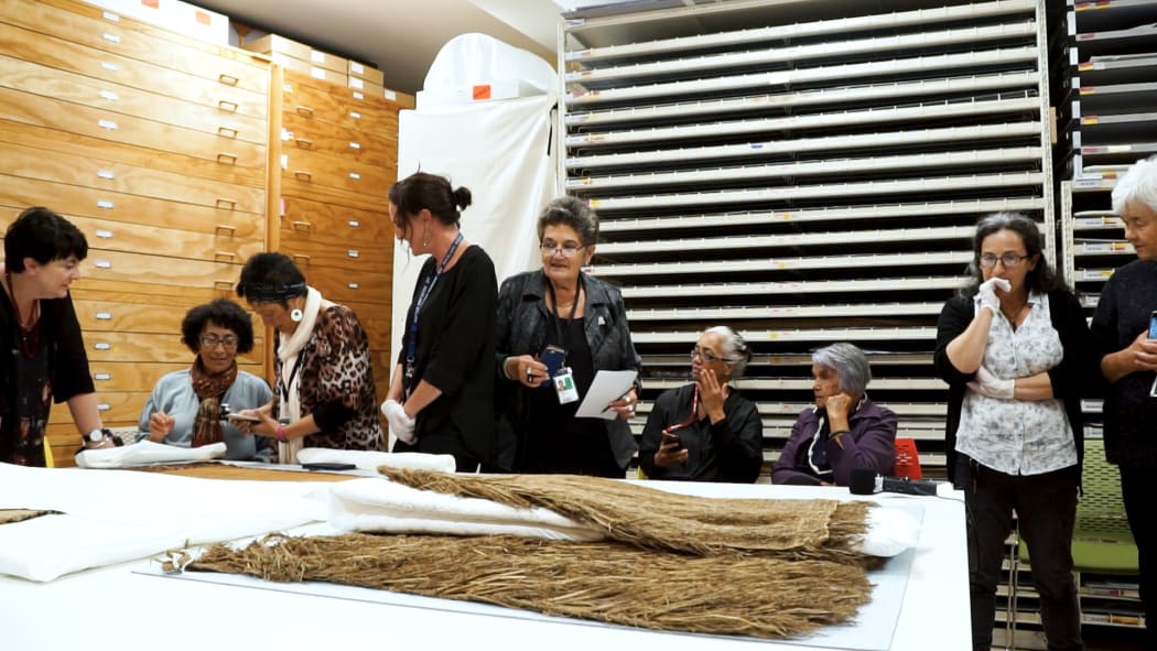 Jami Williams, Rangi Te Kanawa, Kahutoi Te Kanawa, Christina Wirihana, Awhina Tamarapa, Matekino Lawless, Lisa McKendry and Dr Maureen Lander viewing cloaks and rāpaki (waist garment).