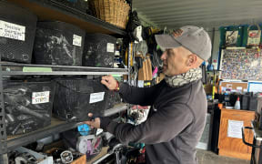 Picture of a man getting bike parts from a shelf.