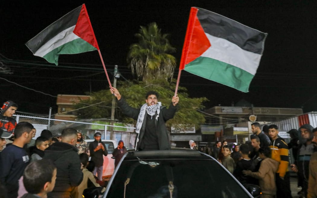 People celebrate along a street at Deir el-Balah in the central Gaza Strip, on January 15, 2025, amid the ongoing war in the Palestinian territory between Israel and Hamas. Crowds of Gazans chanted and embraced on January 15 as news spread that a ceasefire and hostage release deal had been reached between Israel and Hamas aimed at ending more than 15 months of war in the Palestinian territory.