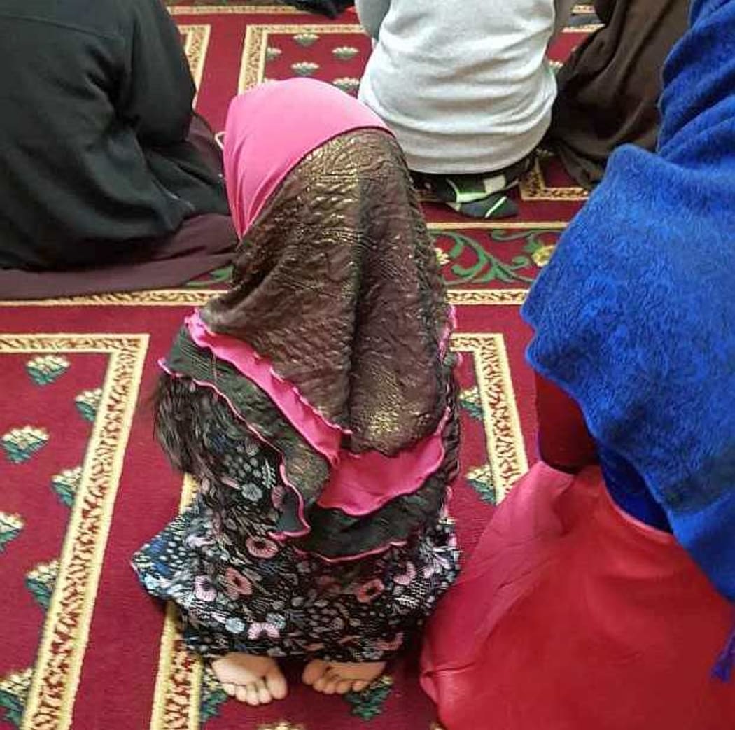Small child in pink and black hijab
