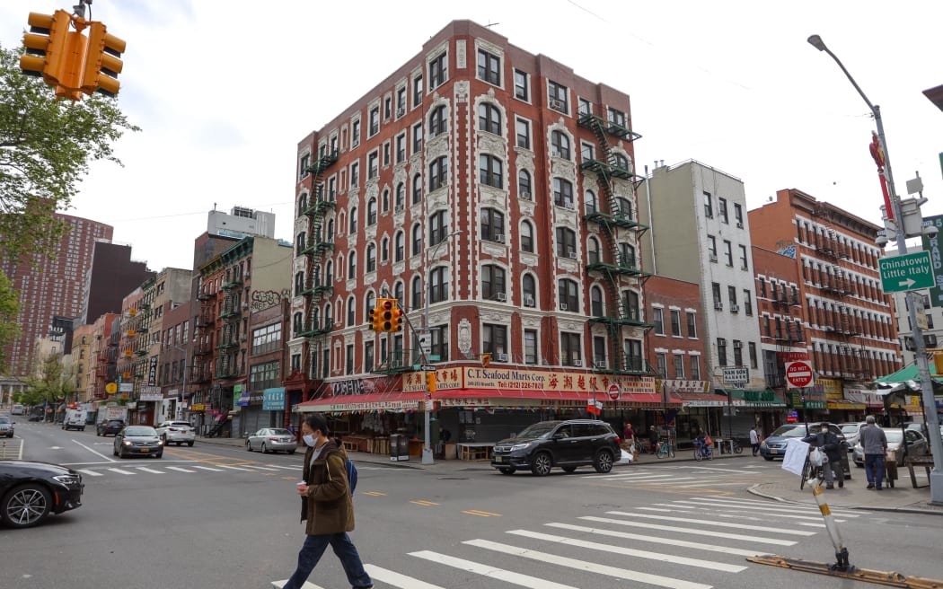 A woman crosses the street in Chinatown
on Manhattan Island in New York City in the United States. New York City is the epicenter of the Coronavirus pandemic (COVID-19). (Photo by William Volcov / BRAZIL PHOTO PRESS / Brazil Photo Press via AFP)
