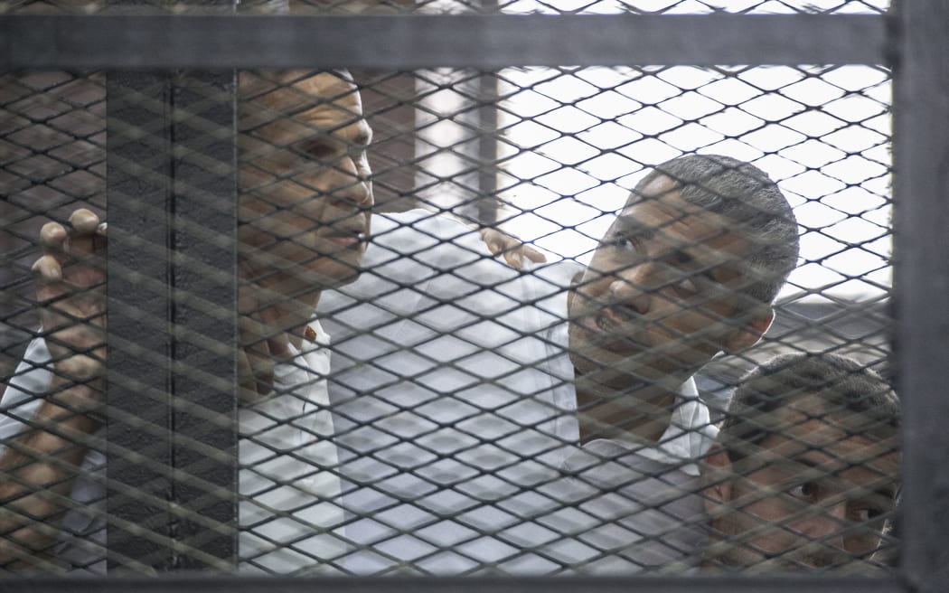 Al-Jazeera news channel's Australian journalist Peter Greste, left, and his colleagues, Egyptian-Canadian Mohamed Fadel Fahmy, centre, and Egyptian Baher Mohamed listen to the original verdict in June.