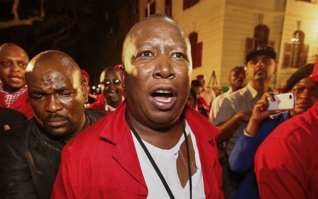 Julius Malema (C) leaves the parliament after being evicted.