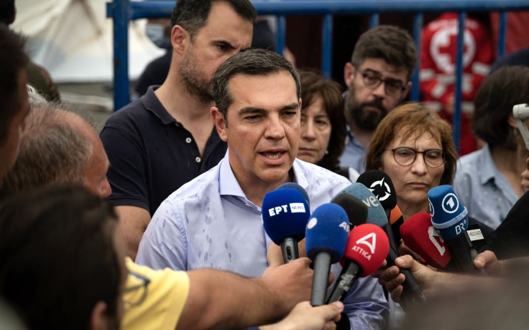 Alexis Tsipras leader of leftist Syriza party speaks to the media after his visits to the survivors of a shipwreck at a warehouse at the port in Kalamata town on June 15, 2023, after a boat carrying migrants sank in international waters in the Ionian Sea. Greece has declared three days of mourning, the interim prime minister's office said on June 14, 2023, over a migrant boat sinking in the Ionian Sea feared to have claimed hundreds of lives. The Greek coastguard has so far recovered 79 bodies and rescued over 100, but survivors are claiming that up to 750 people were on board. (Photo by Angelos TZORTZINIS / AFP)