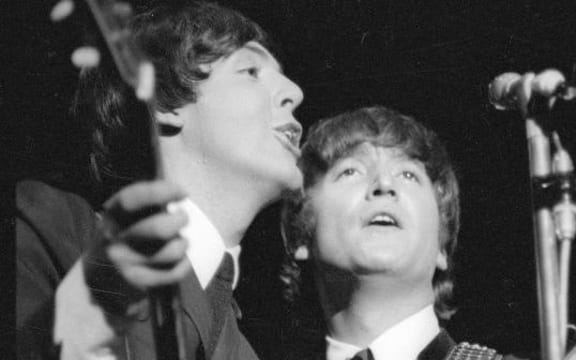 Paul McCartney and John Lennon singing together.