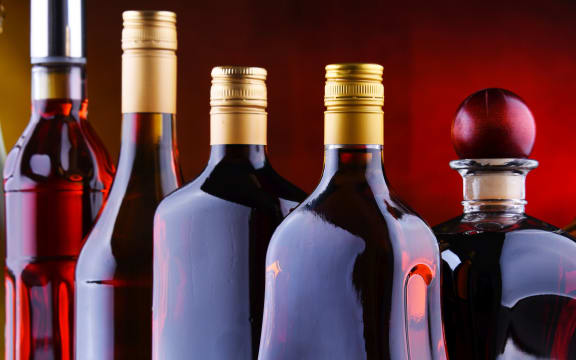 Composition with bottles of assorted alcoholic beverages.