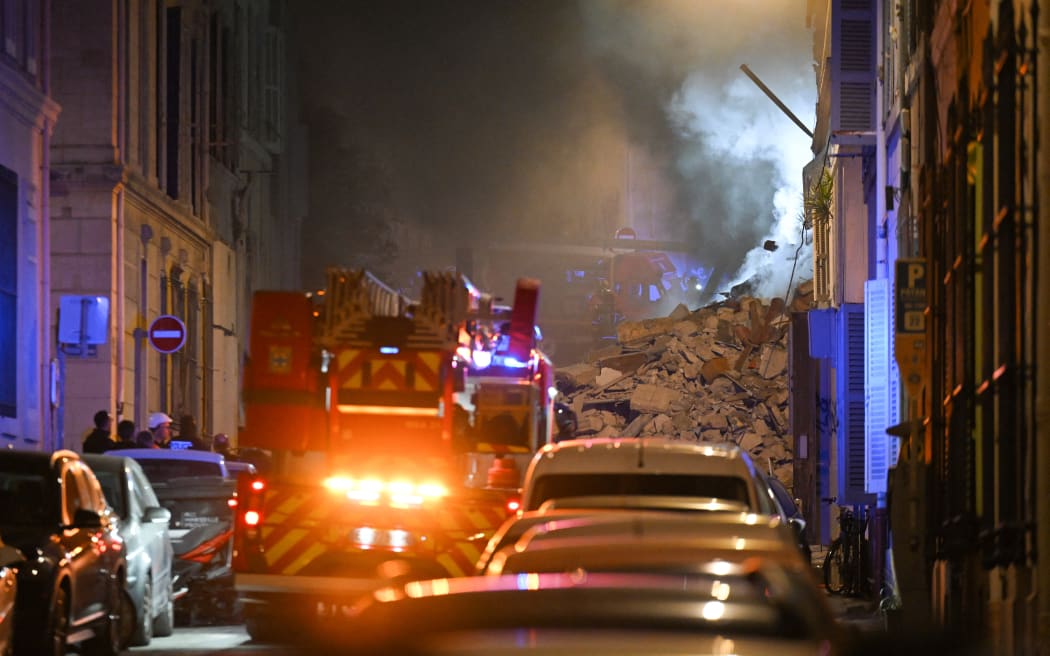 Rescue vehicles gather at the scene where a building collapsed in the southern French port city of Marseille early on April 9, 2023. - A building in the southern French port city of Marseille collapsed, police told AFP early on April 9, though it was unclear whether there were any victims. (Photo by NICOLAS TUCAT / AFP)