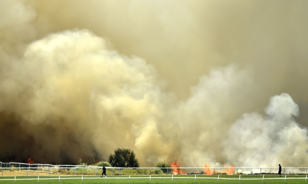 A bushfire burns outside the Perth Cricket Stadium in Perth on December 13, 2019. -