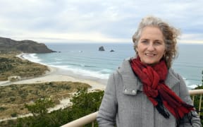 For the penguins sake . . .  Reasearchers have suggested closing off beaches to allow penguins to breed in peace. Yolanda van Heezik with Sandfly bay in behind.