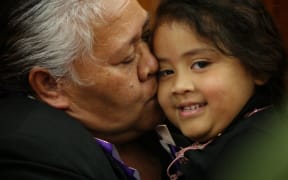 Jonah Lomu's mother, Hepi, cuddles a child after the service.