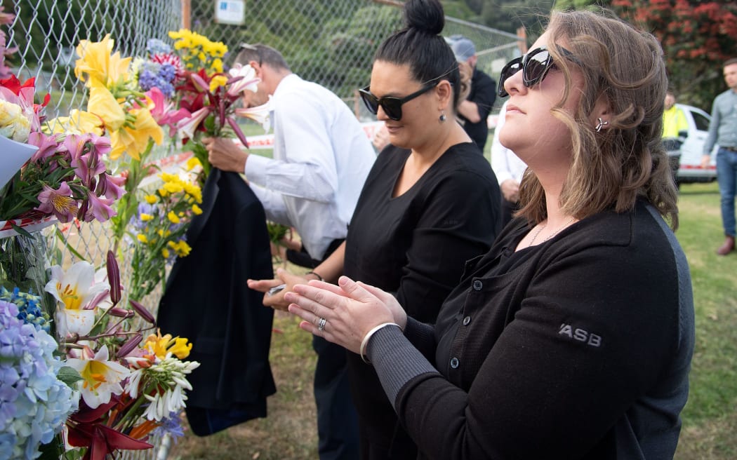 Bouquets of flowers are placed on the waterfront near White Island Tours base in Bay of Plenty,