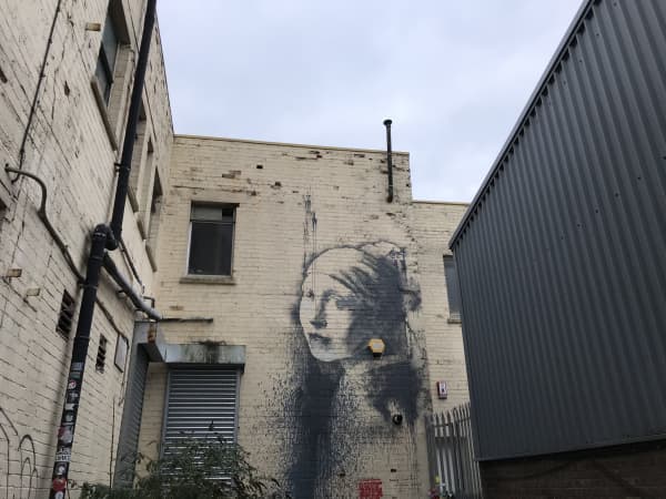 Girl with a Pierced Eardrum is a 2014 mural in Bristol which parodies Johannes Vermeer's 1665 portrait Girl with a Pearl Earring is painted so that an existing security alarm on the wall replaced the large pearl earring worn by the anonymous sitter.
