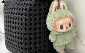 A collectible Labubu plush pendant on Jasmine Kim's handbag.