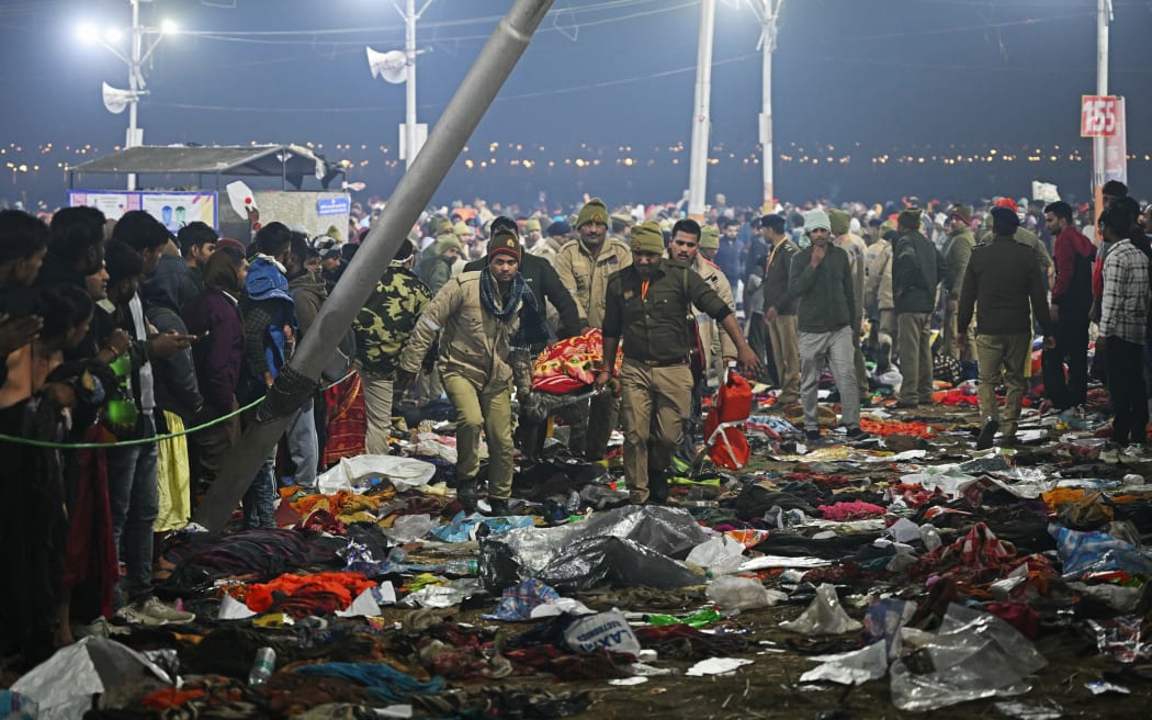 Security personnel carry an injured pilgrim at the site of a stampede amid the ongoing Maha Kumbh Mela festival in Prayagraj on January 29, 2025. (Photo by ARUN SANKAR / AFP)