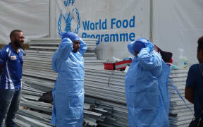 Health workers practice donning personal protective equipment (PPE).