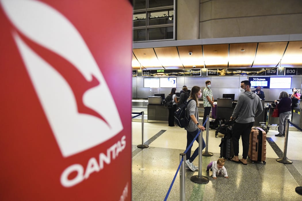 Travelers wait in line after verifying their Covid-19 vaccination status as they check-in for a flight to Sydney.