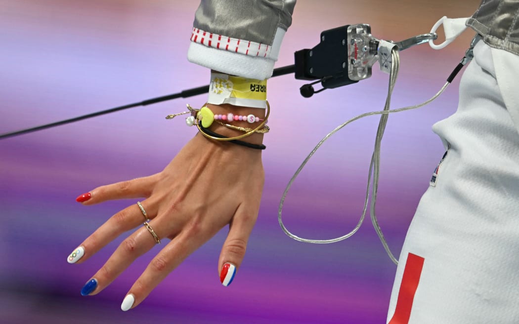 Fencer Sara Balzer competes in the women's sabre individual round donning blue, white and red nails, the colours of the French flag.