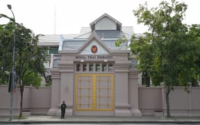 A Cambodian police officer stands guard in front of the Thai embassy in Phnom Penh on July 24, 2025. Cambodian and Thai troops exchanged fire in a new round of clashes at a disputed border area on July 24, 2025, both sides said. (Photo by TANG CHHIN Sothy / AFP)