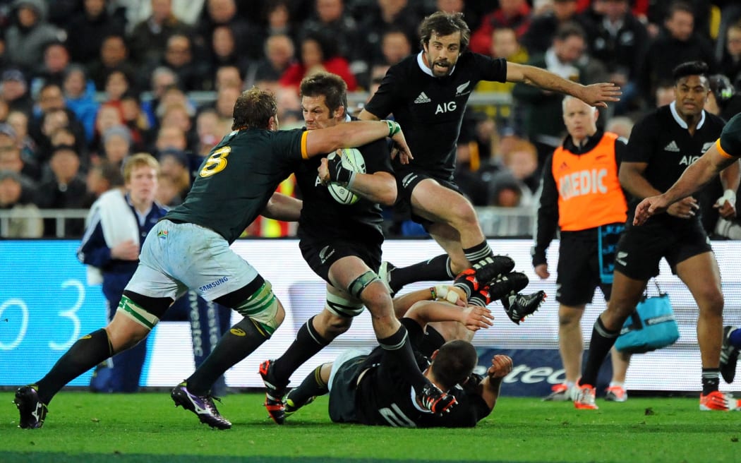 Richie McCaw grapples, Conrad Smith hurdles.