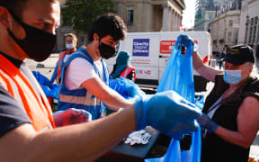 Volunteers from the Charity Begins At Home non-profit group hand out food parcels at a 'mobile food bank' in Trafalgar Square in London.