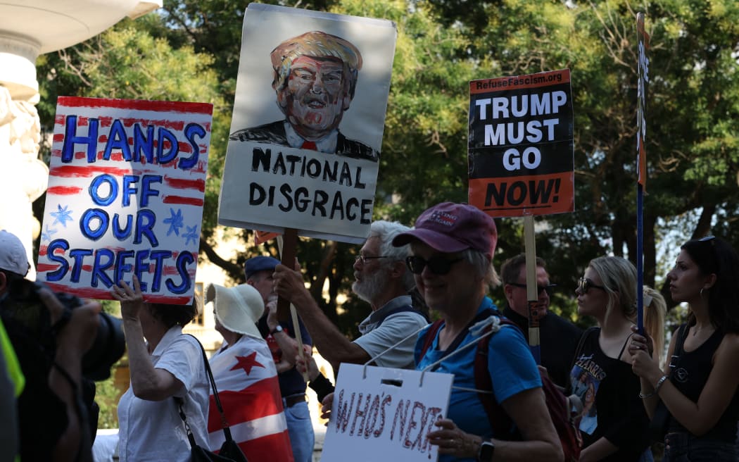 People protest U.S. President Donald Trump’s federalization of DC police and deployment of National Guard troops, in Washington, D.C., U.S., on August 11, 2025.  Trump announced the takeover at a morning press conference, claiming incorrectly that violent crime is at an all-time high in the capital city.  Violent crime dropped by 26 percent over the previous year.