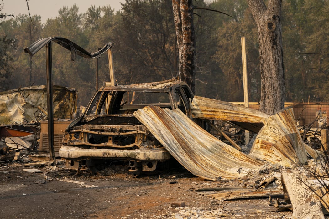 A damaged home and car in a mobile home park destroyed by fire on 10 September 2020 in Phoenix, Oregon.